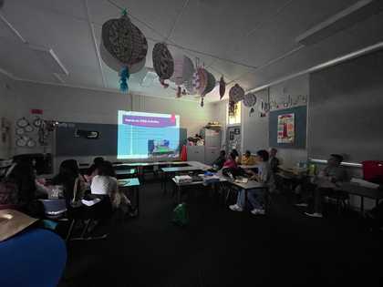 HEC-hosted STEM for Girls session, students seated at desks with a presentation on screen